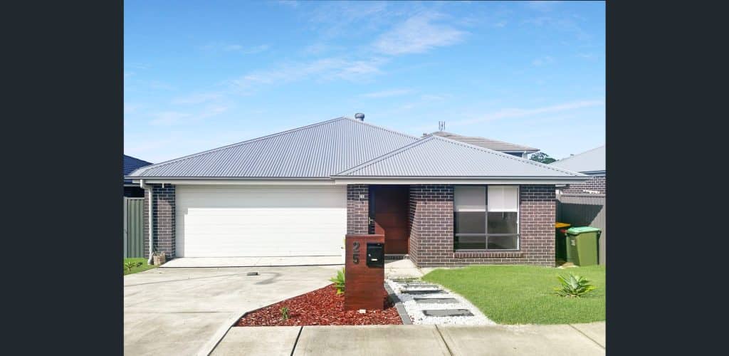 Located on Bradman Drive in Woongarrah, this house features a garage positioned in front of it.