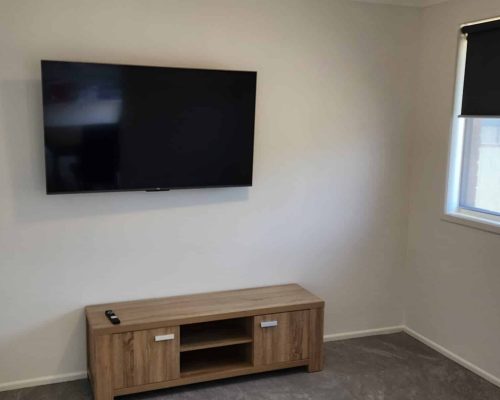 A small room with a tv mounted on the wall.